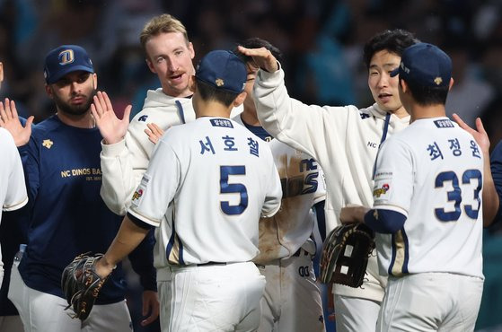 지난 19일 두산과의 와일드카드 결정 1차전이 끝난 뒤 데일리 MVP 서호철을 격려하는 NC 페디(왼쪽에서 두 번째). 연합뉴스