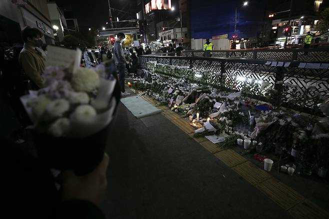 지난해 10월30일, 이태원 참사가 일어난 서울 용산구 이태원 해밀톤호텔 옆에 설치된 임시 분향소를 찾은 한 시민이 헌화하고 있다. ⓒ시사IN 이명익