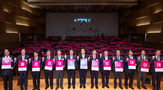 내빈들이 포럼에 참석해 시민들과 함께 퍼포먼스를 하고 있다. 왼쪽부터 이영활 부산상공회의소 상근부회장, 최학범 경남도의회 제1부의장, 구자천 경남상공회의소협의회 회장, 이윤철 울산상공회의소 회장, 서정욱 울산시 행정부시장, 빈대인 BNK금융지주 회장, 이성철 한국일보 사장, 최만림 경남도 행정부지사, 안병윤 부산시 행정부시장, 전호환 동명대학교 총장, 방성빈 부산은행장, 예경탁 경남은행장, 이명호 부산국제금융진흥원장. 부산=이한호 기자