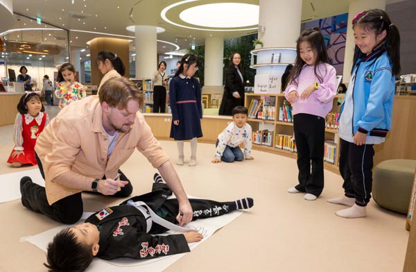 25일 부산시청 1층 들락날락에서 어린이들이 ‘들락날락 부산형 어린이 영어교육 프로그램’에 참여하고 있다. 아이들이 이날 수업 주제인 ‘Body(몸)’ 에 맞춰 커다란 종이에 신체 모양을 본뜨고 있다. 이원준 기자 windstorm@kookje.co.kr