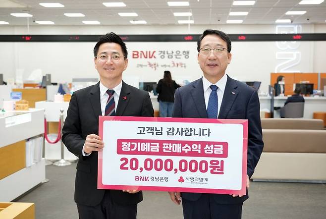 BNK경남은행 신태수 부행장(오른쪽)이 경남사회복지공동모금회 박은덕 사무처장에게 '고객님 감사합니다' 정기예금 판매수익 성금 기탁 증서를 전달하고 있다. BNK경남은행 제공