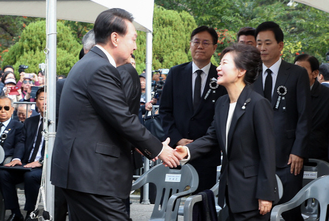 윤석열 대통령이 사우디아라비아·카타르 순방 귀국 직후인 26일 오전 서울 동작구 국립서울현충원에서 열린 박정희 전 대통령 44주기 추도식에 참석해 박근혜(오른쪽) 전 대통령의 손을 잡고 인사를 나누고 있다. 연합뉴스