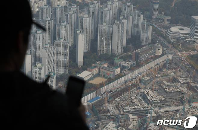 서울 송파구 서울스카이를 찾은 관람객들이 전망대 너머 아파트 단지와 재건축 진행 단지를 바라보고 있다.  2023.10.24/뉴스1 ⓒ News1 박정호 기자