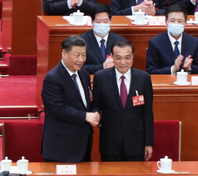 2023년 3월 11일 중국 베이징 인민대회당에서 열린 전국인민대표대회(전인대) 제14기 제1차 회의 제4차 전체회의에서 시진핑(왼쪽) 중국 국가주석이 퇴임하는 리커창(오른쪽) 전 총리와 악수하고 있다. /김남희 기자