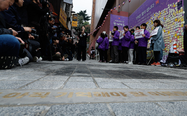 26일 서울 용산구 이태원역 1번 출구 앞에서 권은비 작가가 자신이 디자인한 ‘10·29 기억과 안전의 길’에 대해 설명하고 있다. 이 골목 초입 바닥에 ‘우리에겐 아직 기억해야 할 이름들이 있습니다’라는 글귀가 적혀 있다. 권현구 기자