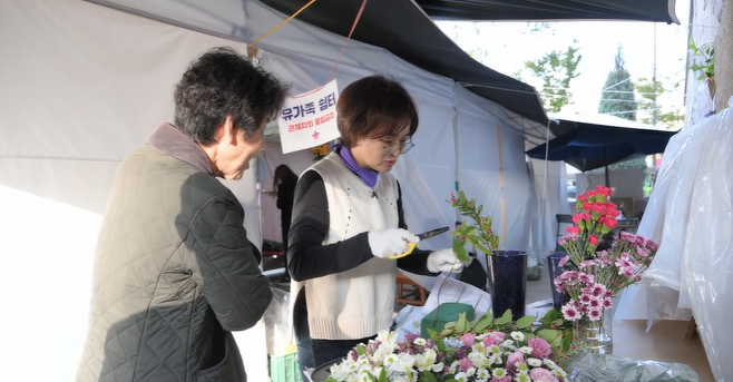 고 최민석 씨의 엄마 김희정 씨가 분향소에 둘 꽃들을 정리하고 있는 모습