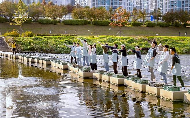 코웨이 임직원들이 흙공을 던지는 모습. (금천구 제공)