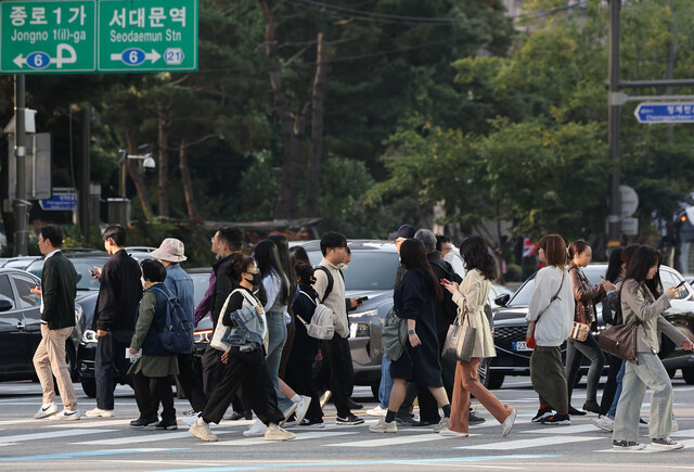 큰 일교차로 중부지방이 쌀쌀한 아침 날씨를 보이는 지난 18일 오전 서울 광화문광장에서 시민들이 외투를 입은 채 걸어가고 있다. 연합뉴스