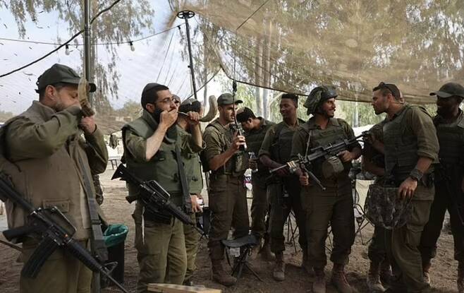 29일(현지시간) 하마스의 최대 무기인 지하터널(땅굴) 입구 인근에서 매복 중이던 하마스 대원들과 교전을 펼치려 이동하기 직전 유대교 의식을 치르는 이스라엘 군인들 AFP 연합뉴스
