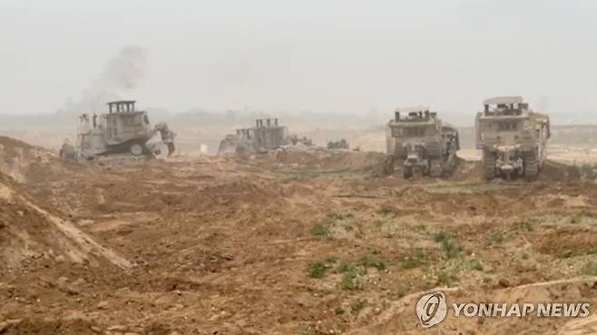 가자지구서 작전 수행하는 이스라엘군 불도저 (가자지구 로이터=연합뉴스) 29일(현지시간) 공개된 영상에서 이스라엘군(IDF)의 장갑 불도저가 가자지구에 있는 모습. 이스라엘은 지상전 확대 명령을 내린 지 48시간 만에 가자지구 서쪽 해안에 있는 자국군 탱크 사진을 공개했다. [IDF 제공 영상 캡처] 2023.10.30 danh2023@yna.co.kr