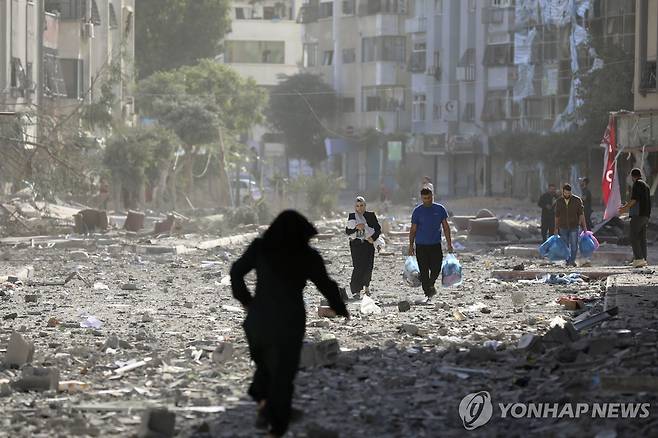 이스라엘군의 공습으로 잿더미로 변한 가자시티에서 사람들이 피란길에 오르고 있다. [AP 연합뉴스 자료사진. 재판매 및 DB 금지]