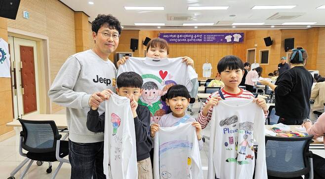 지난 14일 봉화군 석포행복나눔센터에서 영풍 석포제련소 주최로 열린 '티셔츠 꾸미기 대회'에서 한 참가자 가족이 작품을 들어 보이고 있다. /영풍 석포제련소 제공