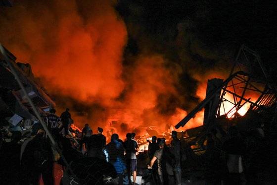 26일(현지시간) 가자시티에 대한 이스라엘의 공습 여파로 건물이 파괴돼 연기와 불이 솟아 오르고 있다. AFP=연합뉴스