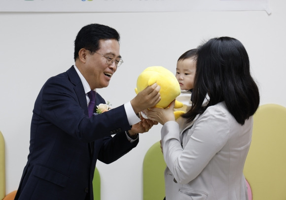 진교훈(왼쪽) 서울 강서구청장이 3일 화곡1동에 문을 연 장난감도서관·공동육아방에서 개소식에 참석한 아기에게 인형을 선물하고 있다. 2023.11.3 강서구 제공