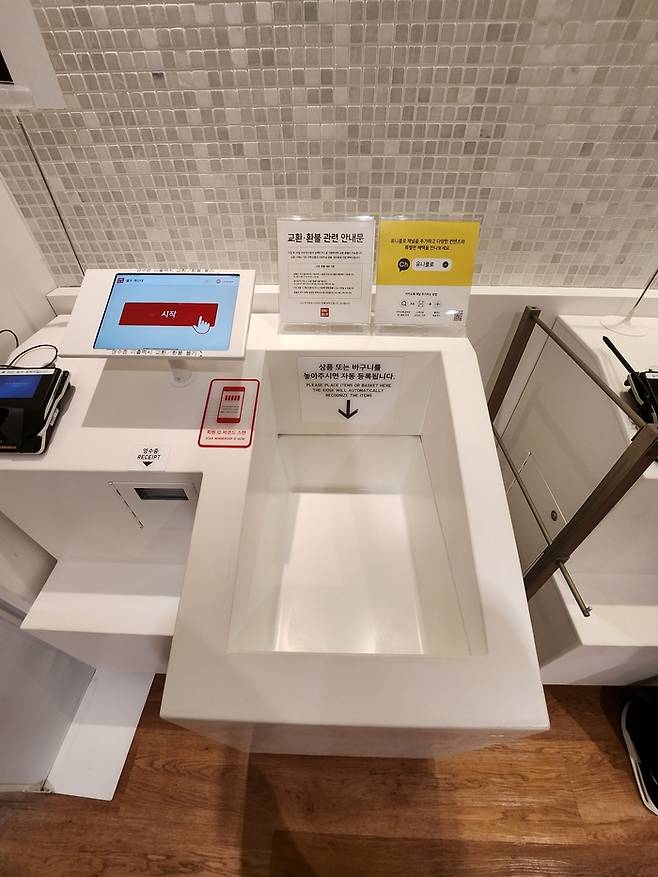 유니클로 무인계산대 모습. 무선 주파수 인식(RFID) 기술을 도입해 사진의 통에 물건을 담으면 품목이 자동으로 계산대에 뜬다.[사진=김현정 기자]