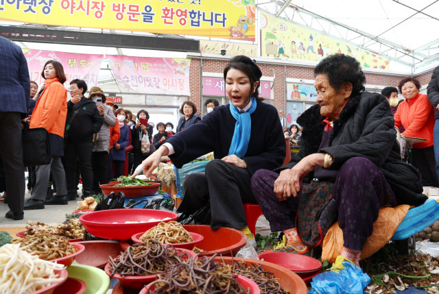 김건희 여사가 7일 전남 순천시 아랫장의 나물채소 가게에서 채소를 구매하고 있다. 대통령실통신사진기자단=연합뉴스