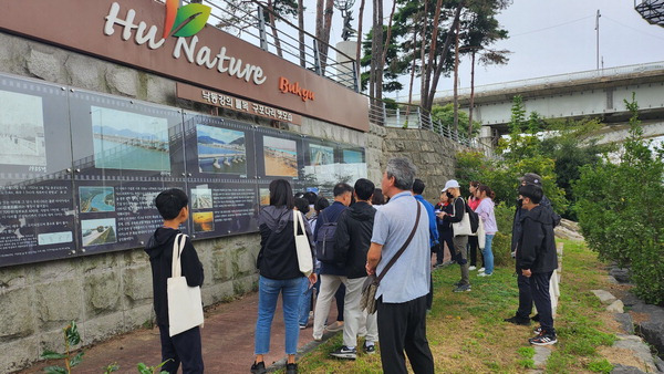 지난달 8일 ‘모여서 탐방’ 행사에 참여한 시민이 구포다리 안내판 앞에서 문화해설사의 설명을 듣고 있다. 오광수 기자