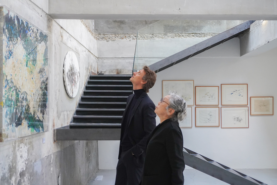 Arthur de Villepin, co-founder and chairman of gallery Villepin in Hong Kong, left, and Korean artist Myonghi Kang, look at Kang's artwork in Kir, a studio in Seongsu-dong of Seongdong District, eastern Seoul, wher Kang's solo exhibit "The Colors of Time is being held. [VILLEPIN]