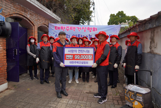 정원주(오른쪽) 대한주택건설협회 회장이 서울 동작구 일대에 거주하는 에너지 취약계층에 연탄을 전달하고 기념촬영을 하고 있다. /사진 제공=대한주택건설협회