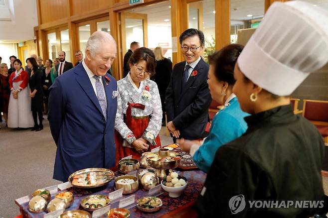 영국 찰스 3세 국왕 (로이터=연합뉴스) 영국 찰스 3세 국왕이 8일(현지시간) 뉴몰든 한인타운을 방문해서 한식 생일상에 관해 설명을 듣고 있다. 2023.11.8 photo@yna.co.kr