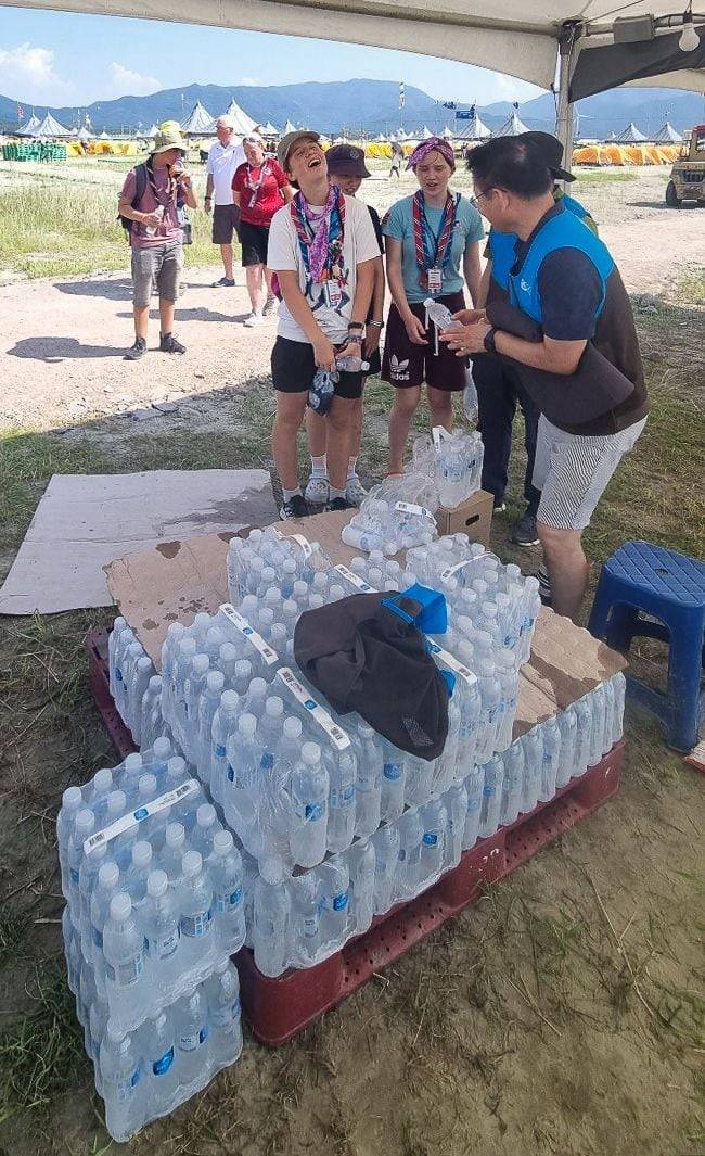 GS25 관계자가 6일 전북 부안에서 열린 2023 새만금 세계잼버리 현장에서 참가자들에게 생수를 나눠주고 있다. (GS리테일 제공) /뉴스1