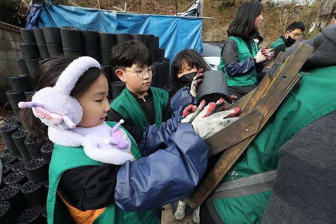고사리 같은 손으로 어른들을 도와 연탄을 지게로 옮기는 아이들. /박성원 기자