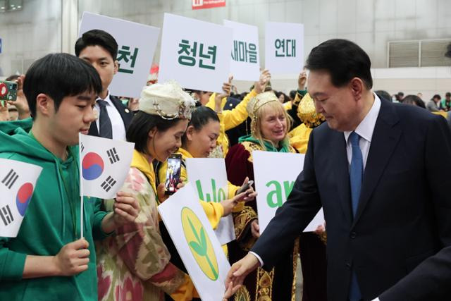 윤석열 대통령이 12일 경기 고양시 킨텍스에서 열린 2023 전국새마을지도자대회에서 대학생 참석자와 악수하고 있다. 대통령실 제공