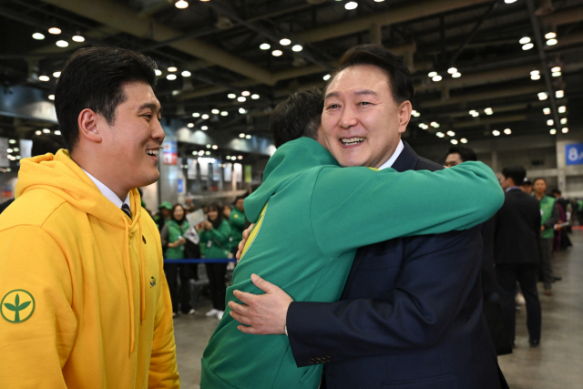 윤석열 대통령이 12일 경기 고양시 킨텍스에서 열린 2023 전국새마을지도자대회 ‘청년의 약속’ 선포식에서 한 청년을 안아주고 있다. 사진제공=대통령실