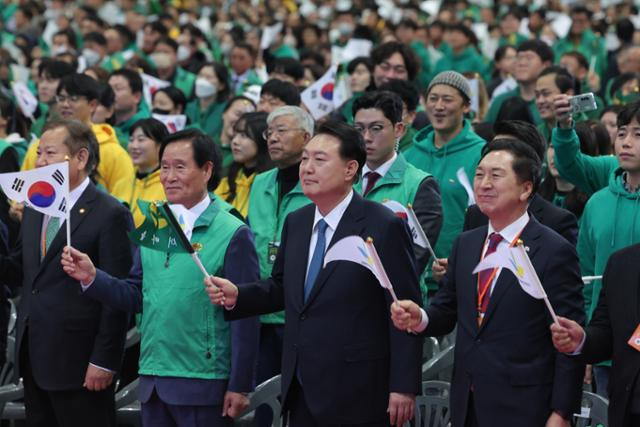 윤석열 대통령이 12일 경기 고양시 킨텍스에서 열린 2023 전국새마을지도자대회에서 태극기를 흔들고 있다. 뉴시스