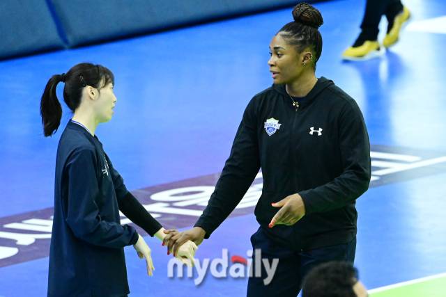 현다건설 김다인(왼쪽)과 모마가 손을 맞잡고 이야기를 나누고 있다 / 한국배구연맹.