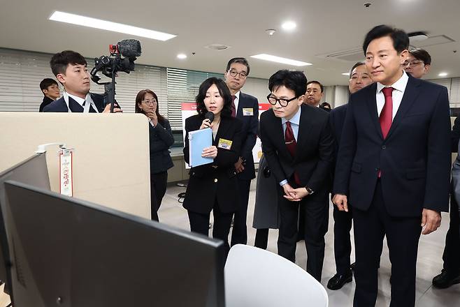 한동훈 법무부 장관과 오세훈 서울시장이 15일 오후 서울 동작구 서울여성플라자에서 열린 법무부-서울시 범죄피해자 원스톱 솔루션 센터 설치·운영 업무협약식에서 서명을 마친 뒤 센터 내 AI 시스템을 시연하고 있다. /연합뉴스