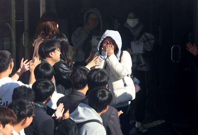 15일 오전 부산 해운대구 신도고등학교에서 고3 수험생들이 후배들의 응원을 받으며 교정을 나서고 있다. 연합뉴스