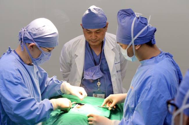 In this file photo from 2014, disgraced scientist Hwang Woo-suk (center) oversees a cloning procedure at Sooam Biotech Research Foundation, which he founded, in Seoul. (Park Hyun-koo/The Korea Herald)