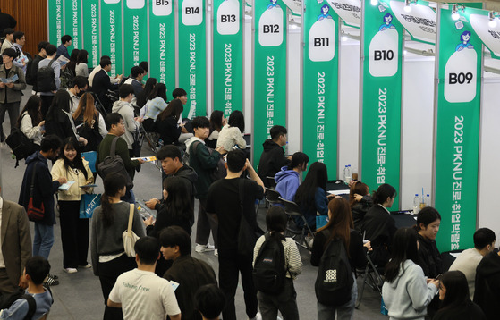 Visitors at a job fair held at Pukyong National University in Busan on Nov. 1 line up in front of job booths. [SONG BONG GEUN]