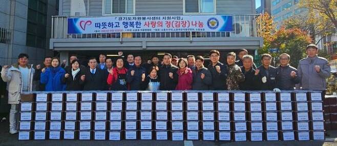 김장김치 봉사에 참여한 대원들과 주민, 정치인, 경찰관이 모여 기념촬영을 하고 있다.