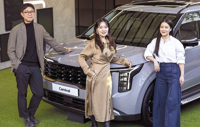 기아 ‘더 뉴 카니발’ 디자이너인 윤재훈(왼쪽부터), 서예림, 배진 연구원이 ‘더 뉴 카니발’ 앞에서 포즈를 취하고 있다. [기아 제공]
