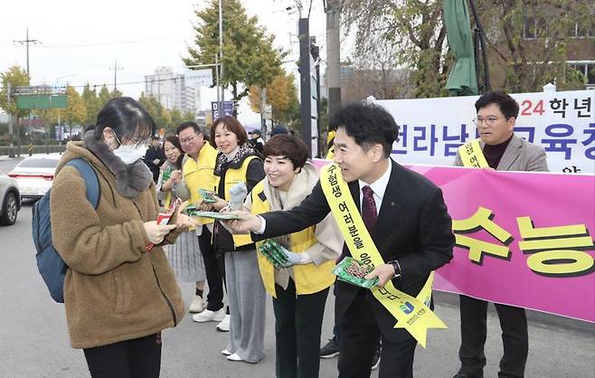 김대중 전남도교육감이 16일 2024학년도 대학수학능력시험장인 광양여고를 찾아 수험생에게 핫팩을 전달하며 격려하고 있다. 전남도교육청 제공