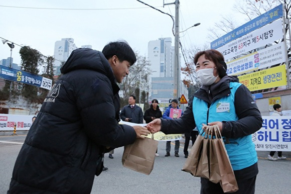 현대제철 당진제철소 마중물 봉사단원이 지역 수험생에게 생수와 핫팩을 전달하고 있다  [사진=현대제철]