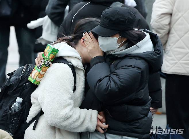 [서울=뉴시스] 조성우 기자 = 2024학년도 대학수학능력시험일인 16일 서울 중구 이화여자외국어고등학교에서 수능 시험을 마친 수험생이 엄마 품에 안겨 울고 있다. 2023.11.16. xconfind@newsis.com