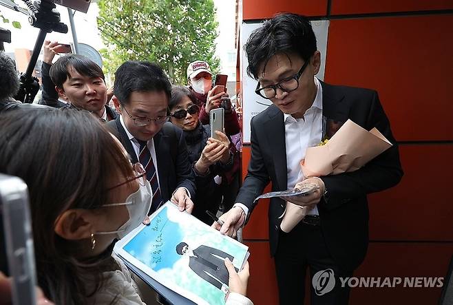 한동훈 법무부 장관이 17일 대구 수성구 스마일센터 방문 중 시민들에게 사인을 해주고 있다. 연합뉴스