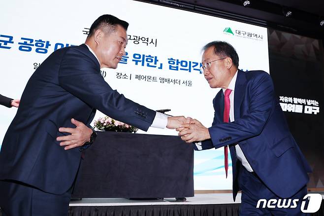 홍준표 대구시장(오른쪽)과 신원식 국방부 장관이 20일 오전 서울 영등포구 여의도 페어몬트 앰배서더 호텔에서 열린 '대구경북신공항 투자설명회'에서 대구 군공항 이전 사업 합의각서 체결 뒤 악수를 하고 있다. 2023.11.20/뉴스1 ⓒ News1 민경석 기자