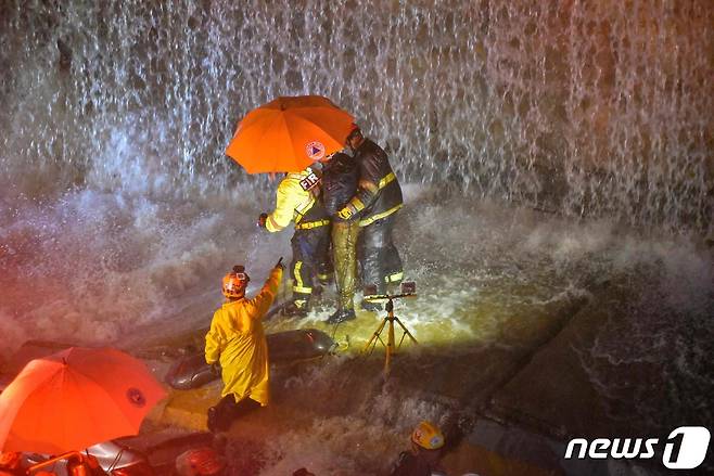 도미니카공화국에 기록적인 폭우가 내려지는 가운데 18일(현지시간) 구조대원들이 붕괴된 벽에 갇힌 사람들을 수색해 부축하고 있다. 2023.11.18 ⓒ AFP=뉴스1 ⓒ News1 정지윤 기자