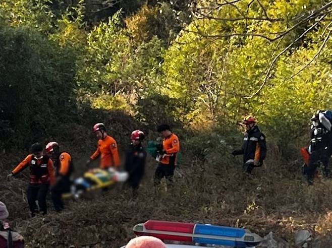 구조대원들이 산에서 추락한 요구조자를 들것에 실어 옮기고 있다. [사진제공=남해경찰서]