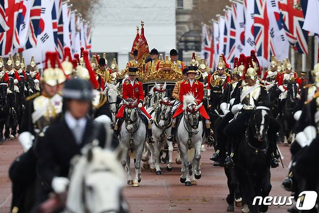 윤석열 대통령과 찰스 3세 영국 국왕을 태운 왕실 마차 행렬이 21일(현지시간) 호스 가즈(Horse Guards) 광장에서 버킹엄궁으로 이어지는 '더 몰'(The Mall) 대로를 지나고 있다. 김건희 여사는 카밀라 왕비와 같은 마차에 탑승했다. 2023.11.21/뉴스1 ⓒ 로이터=뉴스1 ⓒ News1 정지형 기자