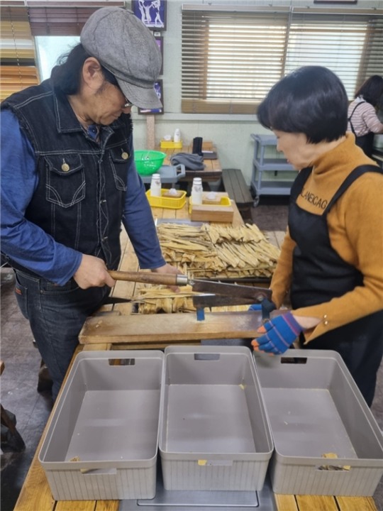 김태형 대표와 아내가 황태를 작두로 썰고 있다.