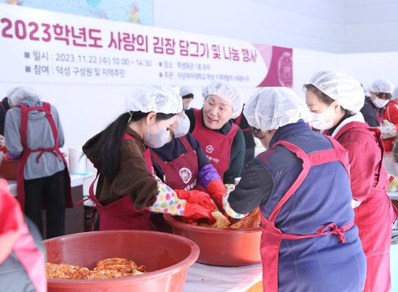 김건희 총장(가운데)이 봉사자들 속에서 함께 김장을 담그며 격려하고 있다.