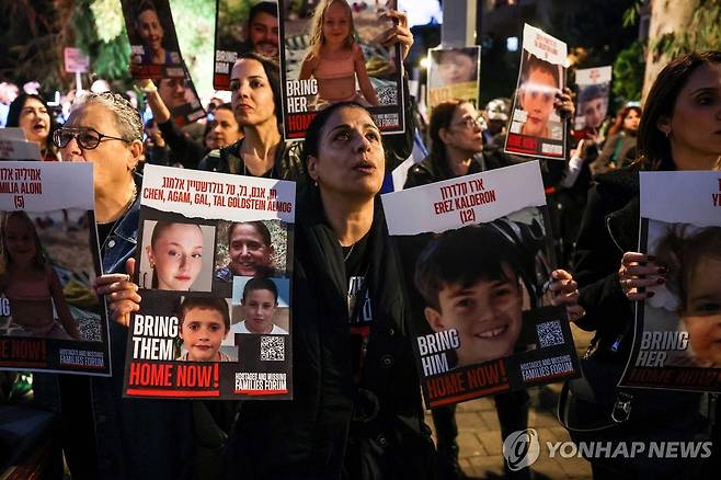 어린이 인질 석방 요구 시위하는 여성 (텔아비브 AFP=연합뉴스) 20일(현지시간) 이스라엘 텔아비브의 유엔아동기금(UNICEF·유니세프) 사무소 밖에서 가자지구에 억류된 이스라엘인 인질의 석방을 요구하는 시위가 열린 가운데 한 여성이 어린이 인질의 사진을 들고 있다. 미국 정부는 21일 팔레스타인 무장 정파 하마스가 석방하기로 한 인질 50명에 미국 국적의 여성 2명과 3살짜리 어린이 1명이 포함됐다고 밝혔다. 2023.11.22 besthope@yna.co.kr