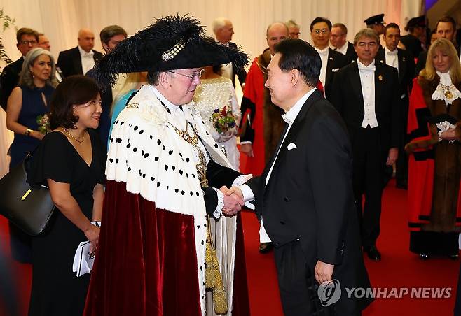 윤석열 대통령, 런던금융특구 시장 주최 만찬 참석 (런던=연합뉴스) 임헌정 기자 = 영국을 국빈 방문한 윤석열 대통령이 22일(현지시간) 런던 금융특구 길드홀에서 열린 런던금융특구 시장 주최 만찬에 도착해 마이클 마이넬리 런던 금융특구 시장의 영접을 받고 있다. 2023.11.23 kane@yna.co.kr