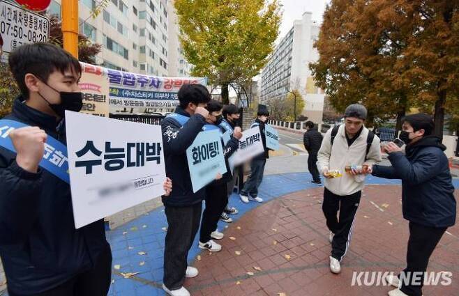 2024학년도 대학수학능력시험일인 16일 오전 서울송파구 보인고등학교 앞에서 수험생이 한 외식업체 직원들이 나눠주는 음료와 응원을 받으며 입장하고 있다. 사진=곽경근 대기자