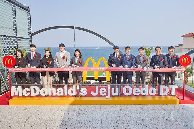 지난 23일 김기원 한국맥도날드 대표이사(왼쪽 다섯 번째)와 맥도날드 관계자들이 제주외도DT점 3층에서 오픈 기념 테이프 커팅식을 진행하고 있다./사진제공=맥도날드